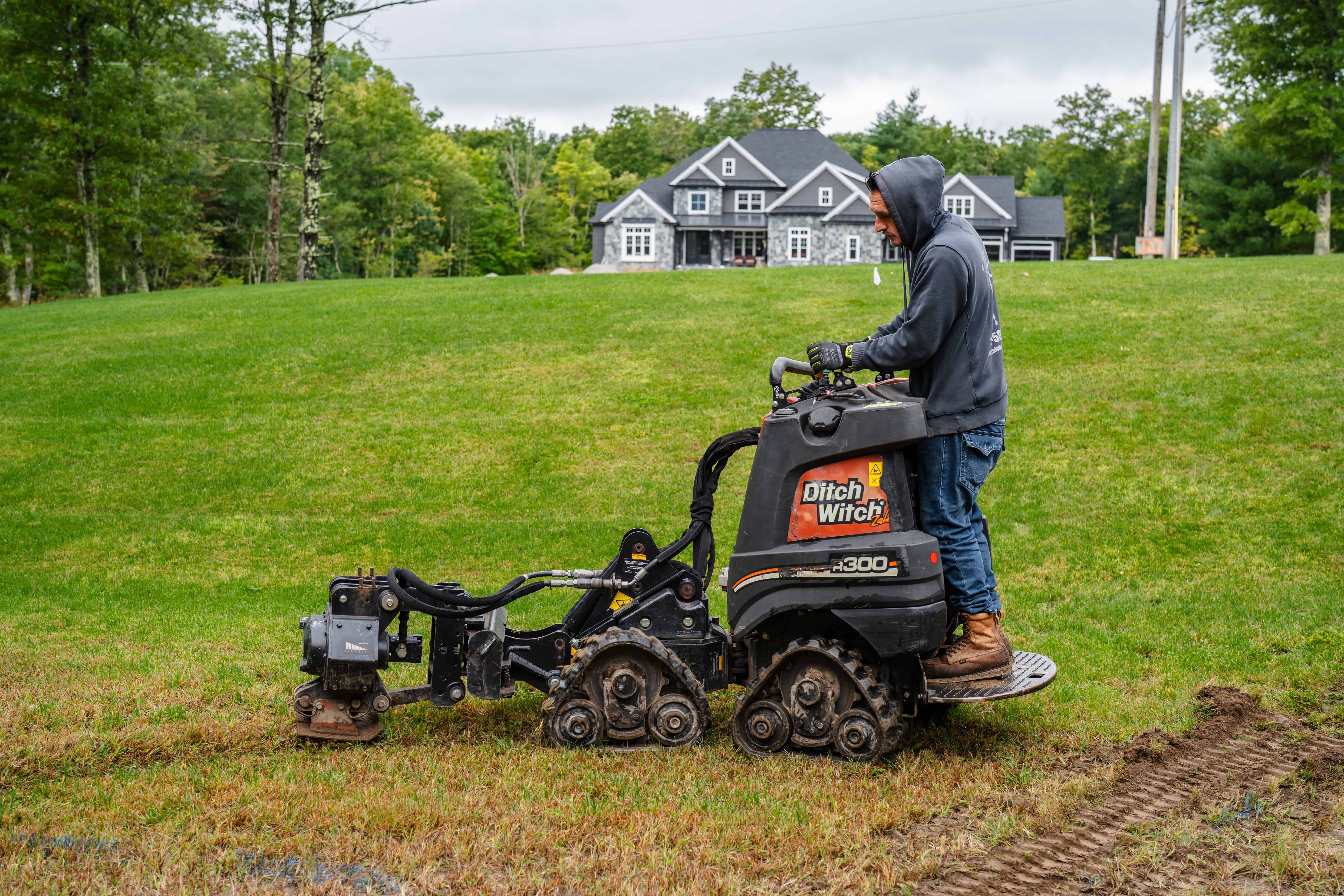 Rainfall Irrigation crew member operating installation equipment on a residential lawn